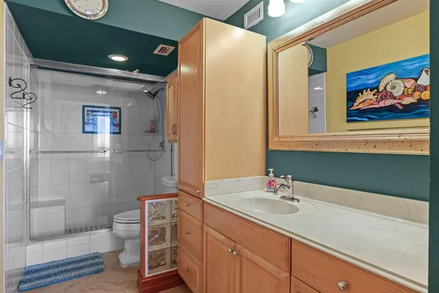 a bathroom with a sink a toilet and shower