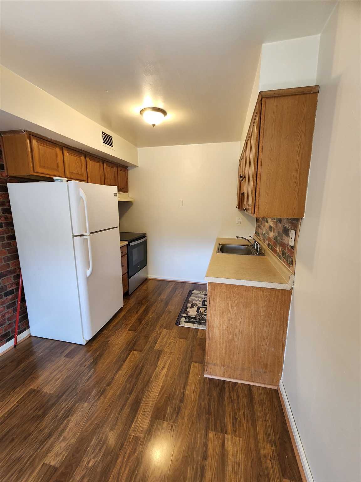 a utility room with wooden floor washer and dryer