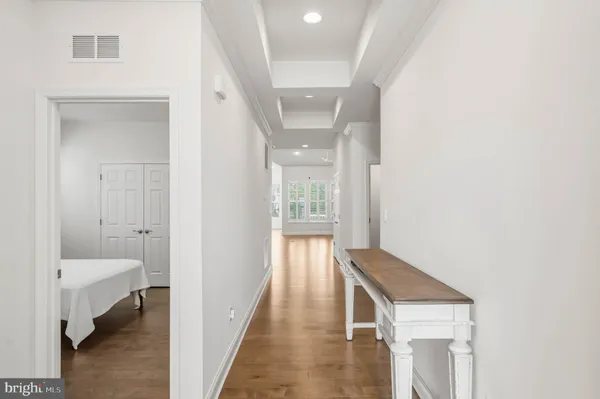 a view of a hallway with wooden floor and staircase