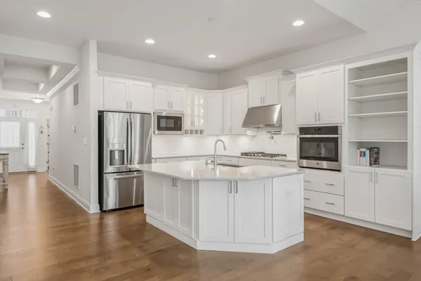 a kitchen with stainless steel appliances granite countertop a refrigerator and a stove top oven