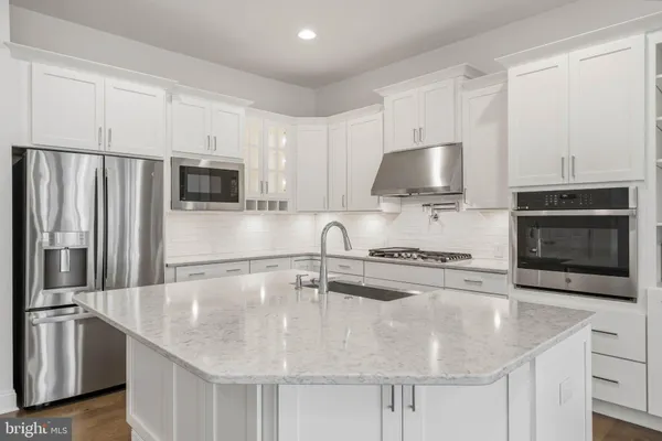 a kitchen with stainless steel appliances a stove a sink a microwave and refrigerator