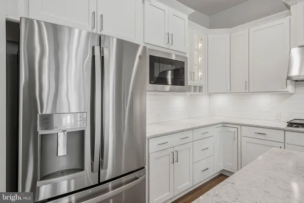 a kitchen with stainless steel appliances white cabinets and a refrigerator