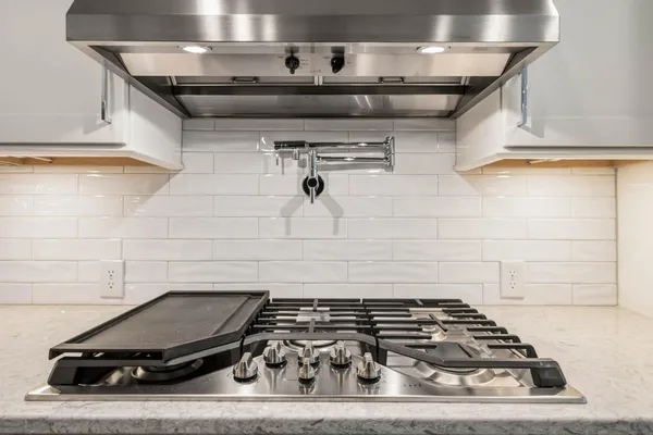 a kitchen with granite countertop a sink stainless steel appliances and cabinets