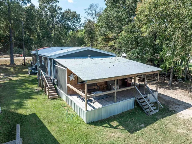 a view of a deck with a big yard and large trees