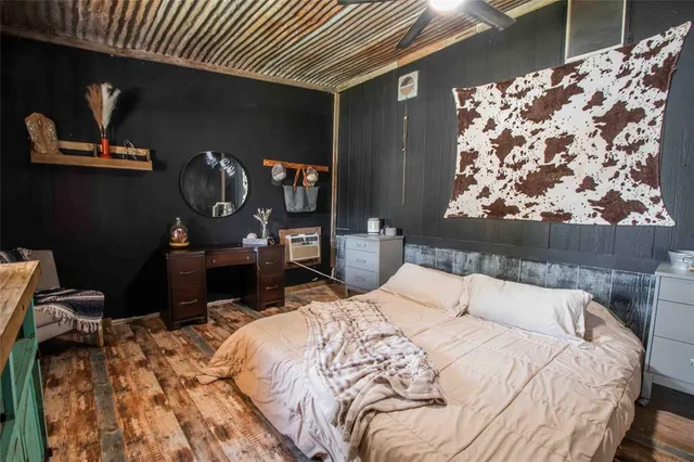 a bed sitting in a bedroom next to a window with chair and fireplace