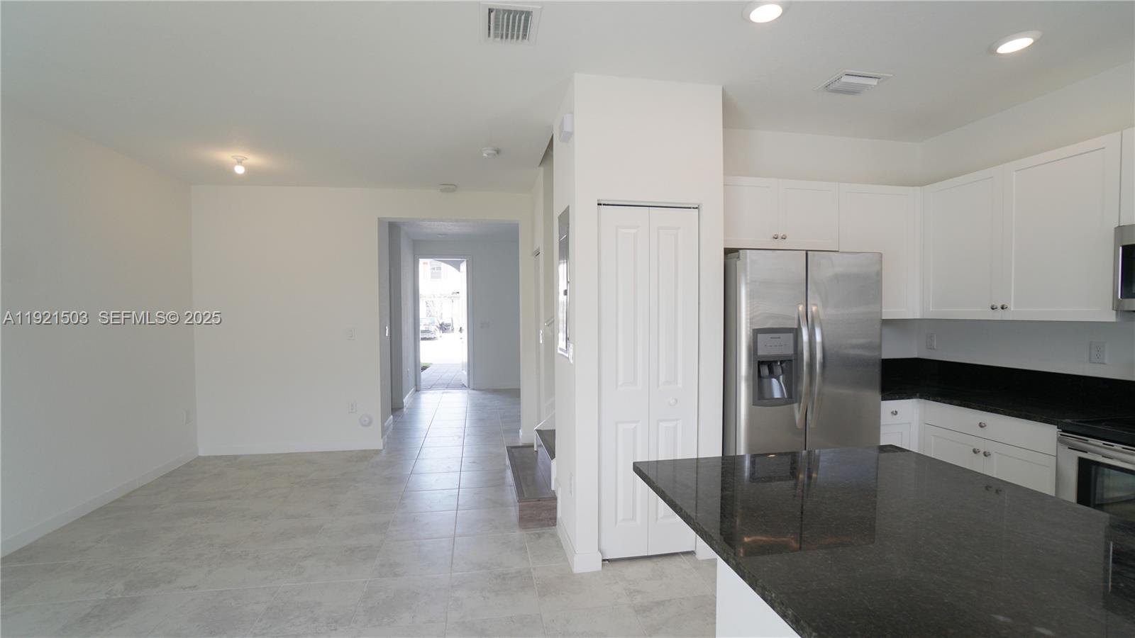 11214 Southwest 249th Street Homestead, FL 33032 - Photo 5 of 16 a kitchen with stainless steel appliances granite countertop a refrigerator a stove and a sink with wooden floor