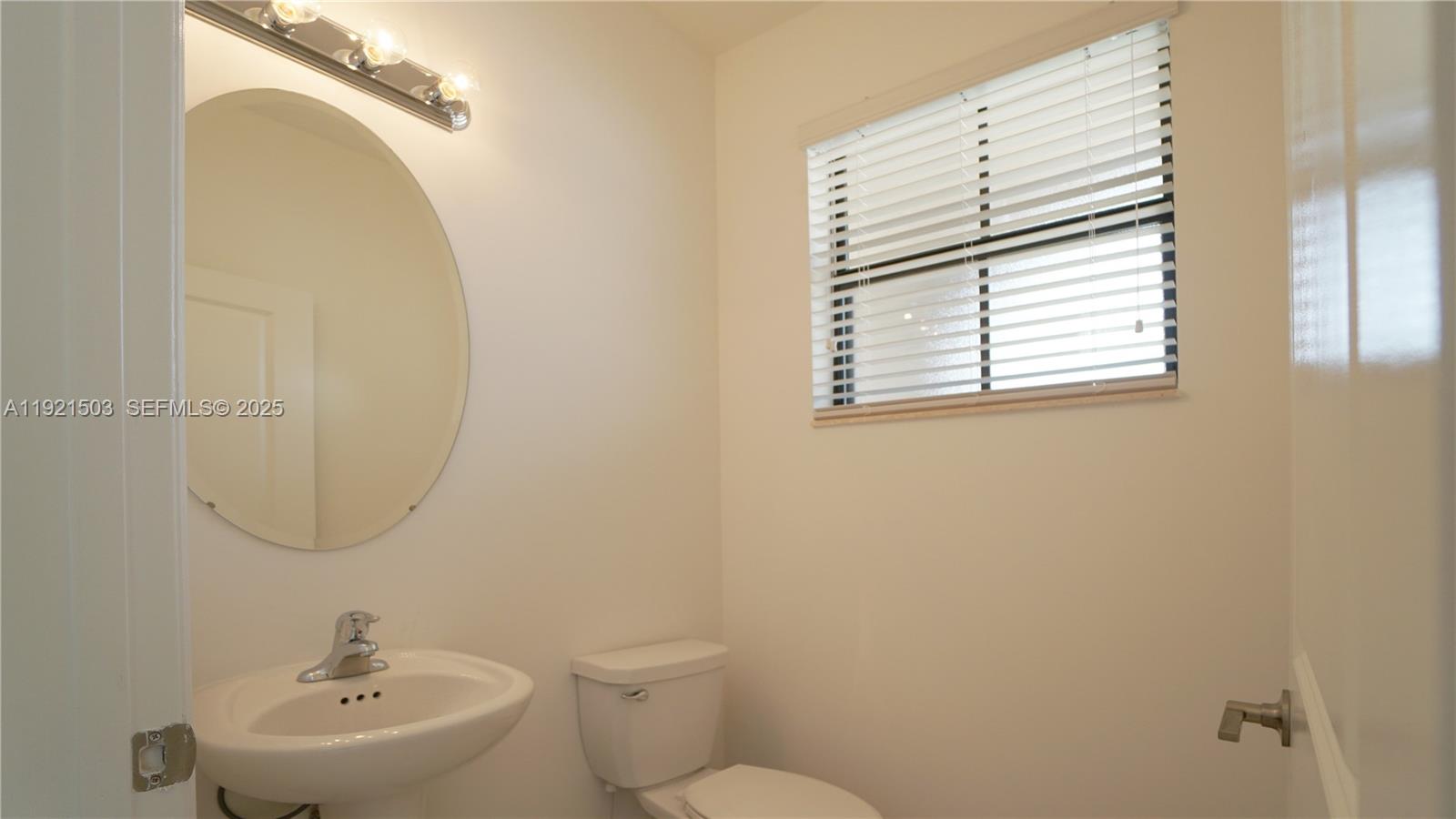 11214 Southwest 249th Street Homestead, FL 33032 - Photo 7 of 16 a bathroom with a toilet sink and mirror