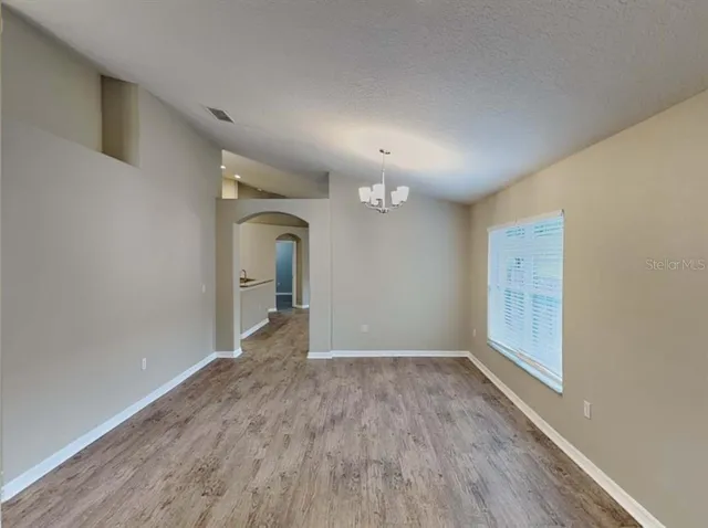 a view of a big room with wooden floor and window