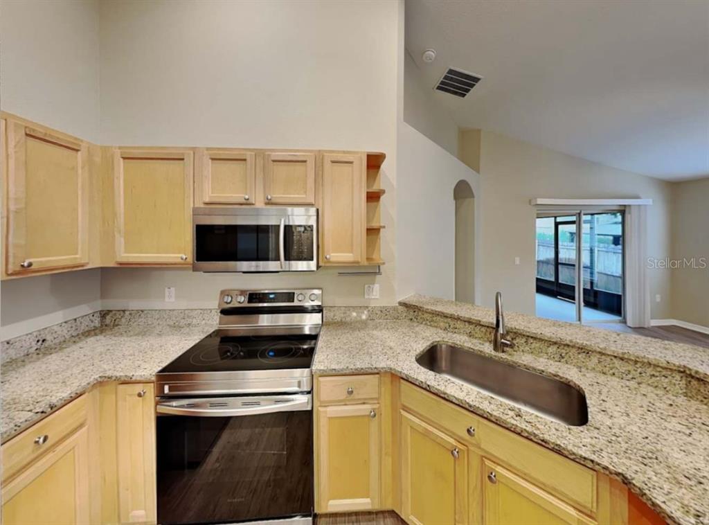 1805 Concord Drive Apopka, FL 32703 - Photo 7 of 12 a kitchen with granite countertop a sink a stove and cabinets