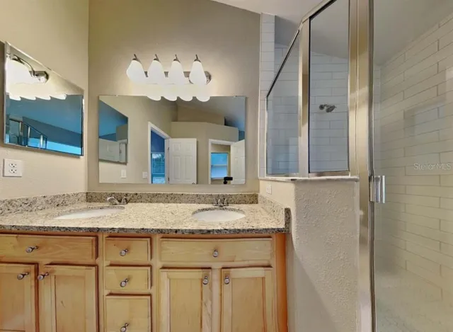 a bathroom with a granite countertop sink and a mirror