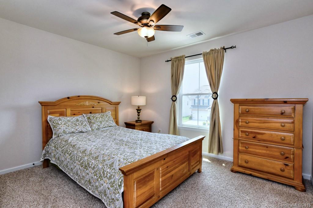 1605 Ridgehaven Road Waxhaw, NC 28173 - Photo 18 of 24 a bedroom with a bed and a chandelier