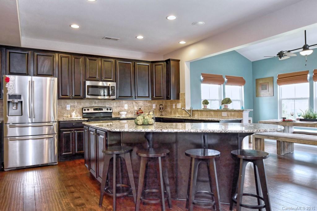 1605 Ridgehaven Road Waxhaw, NC 28173 - Photo 6 of 24 a kitchen with kitchen island granite countertop wooden floors appliances and sink