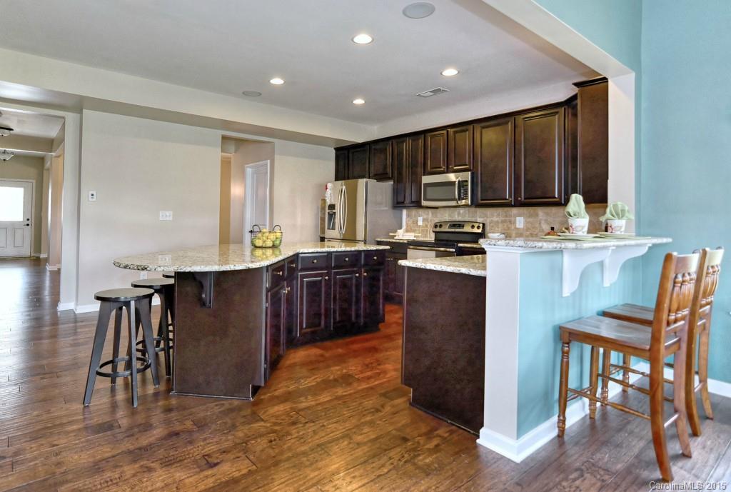 1605 Ridgehaven Road Waxhaw, NC 28173 - Photo 9 of 24 a kitchen with kitchen island granite countertop wooden floors cabinets a sink and appliances