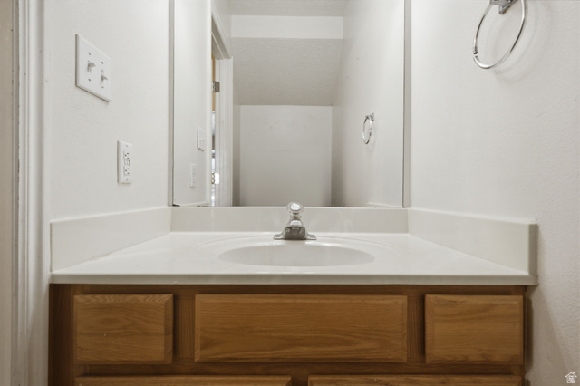 794 East 950 S Street Provo, UT 84606 - Photo 23 of 28 Bathroom vanity featuring an integrated sink, laminate countertop, and wood-finish cabinetry
