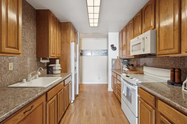 a kitchen with stainless steel appliances granite countertop a stove a sink dishwasher and a refrigerator