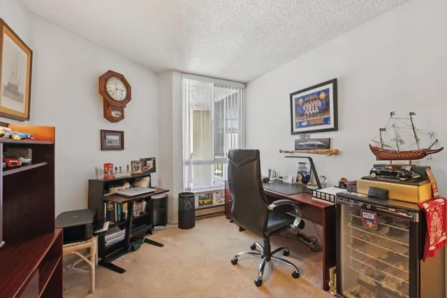 a view of a workspace with furniture and a window