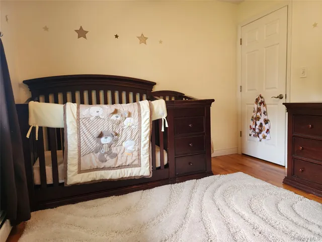 a view of a bedroom with wooden floor and a ceiling fan