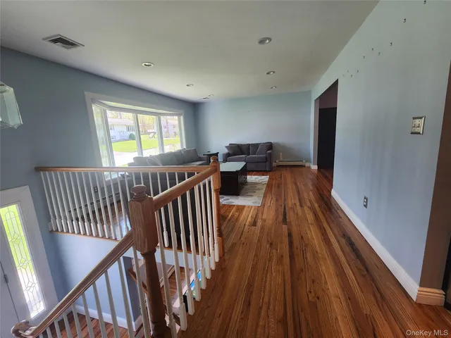 a view of a hallway with wooden floor and staircase