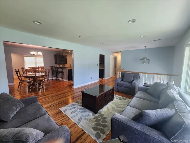 a living room with furniture wooden floor and a table