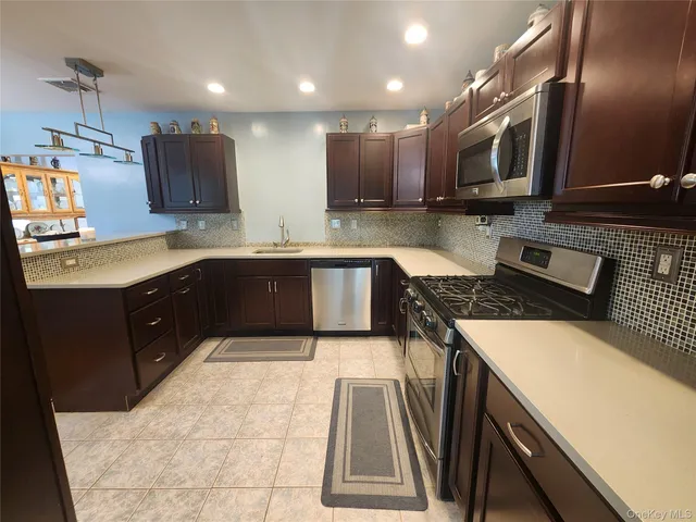 a kitchen with stainless steel appliances granite countertop a sink and a stove