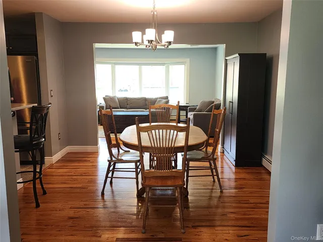 a dining room with furniture a chandelier and wooden floor