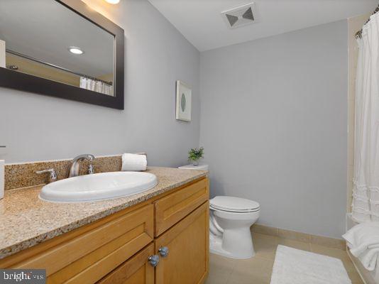 1150 K Street Northwest, Unit 709 Washington, DC 20005 - Photo 23 of 25 a bathroom with a granite countertop toilet a sink and mirror