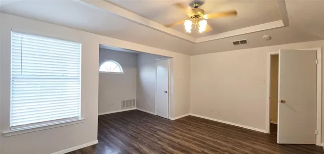 a view of an empty room with window and wooden floor