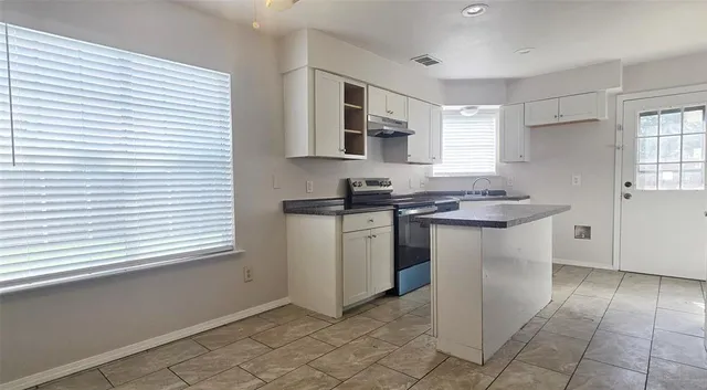 a kitchen with a sink cabinets and window