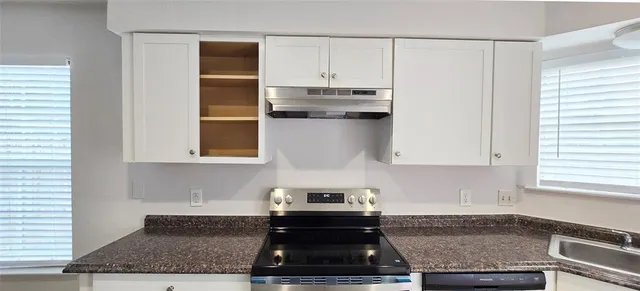 a kitchen with granite countertop white cabinets and white appliances