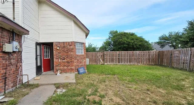a view of a backyard with wooden fence