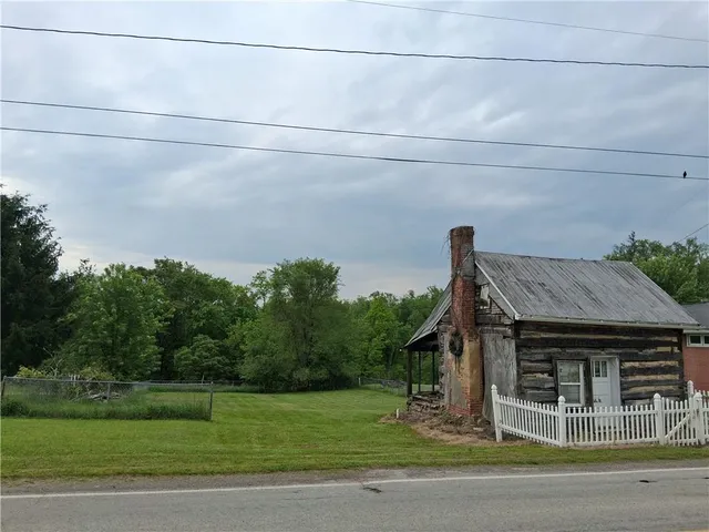 a view of a house with a backyard and trees