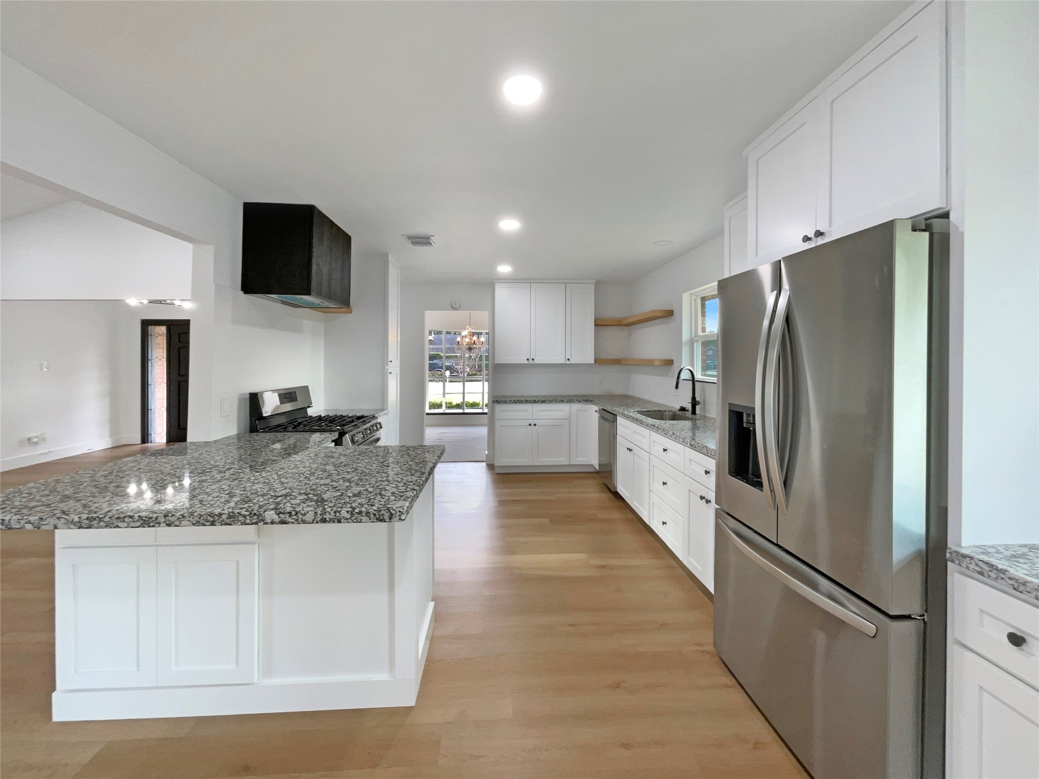 3302 Windsor Drive Pearland, TX 77581 - Photo 11 of 21 a large kitchen with stainless steel appliances kitchen island granite countertop a refrigerator a stove a sink and a microwave