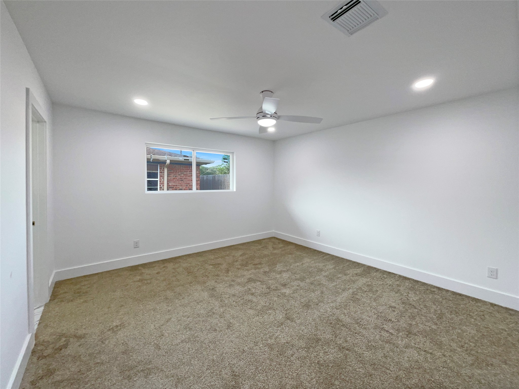 3302 Windsor Drive Pearland, TX 77581 - Photo 16 of 21 an empty room with a ceiling fan and window