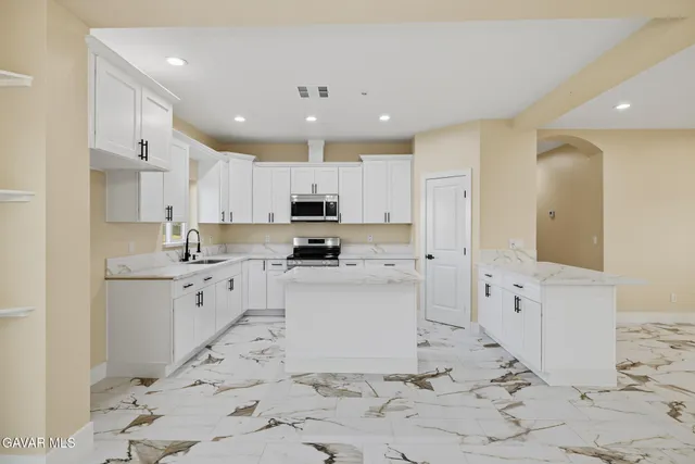 a kitchen with granite countertop white cabinets and white appliances
