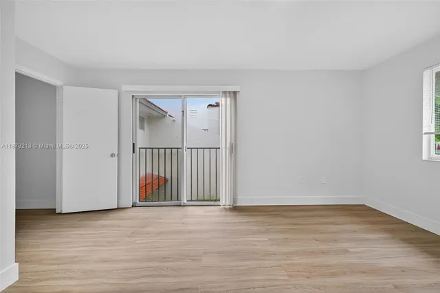 a view of a room with wooden floor and mirror