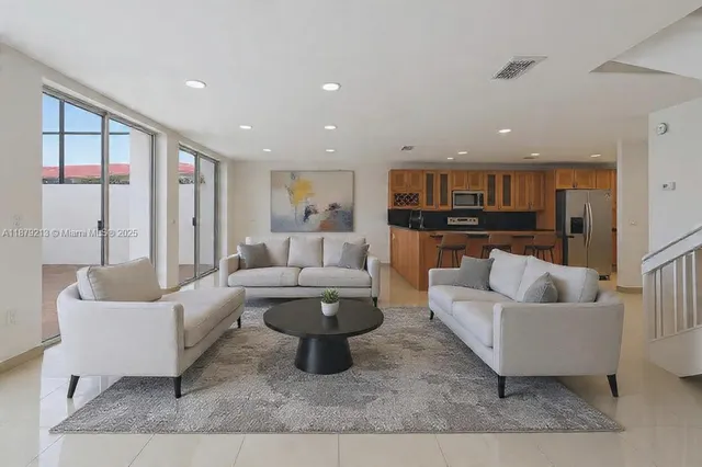 a living room with furniture and a kitchen