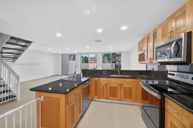 a kitchen with stainless steel appliances a sink stove and cabinets