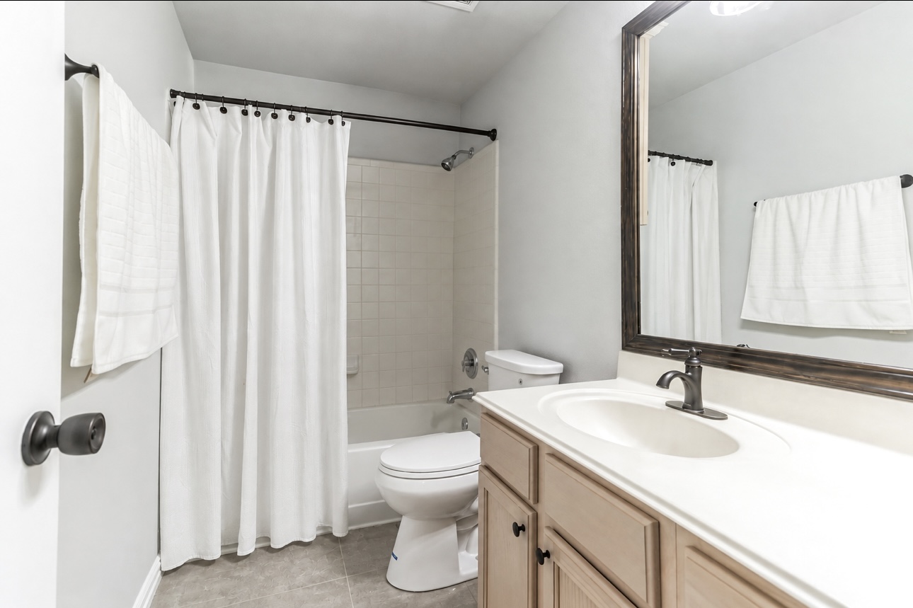 156 Keystone Loop Kyle, TX 78640 - Photo 12 of 23 Clean tiling and a wood vanity define this functional full bathroom.