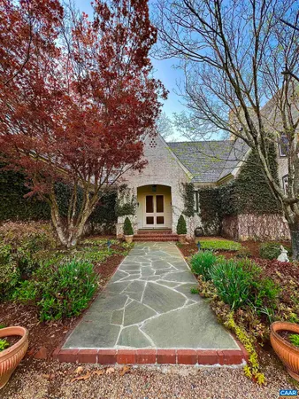 a kitchen with granite countertop a stove a sink a dining table and chairs with wooden floor