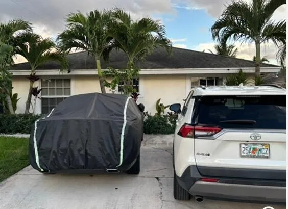 a car parked in front of a house with a yard