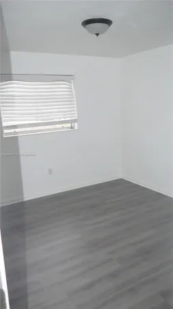 a view of a small space with wooden floor and a window