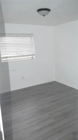 a view of a small space with wooden floor and a window