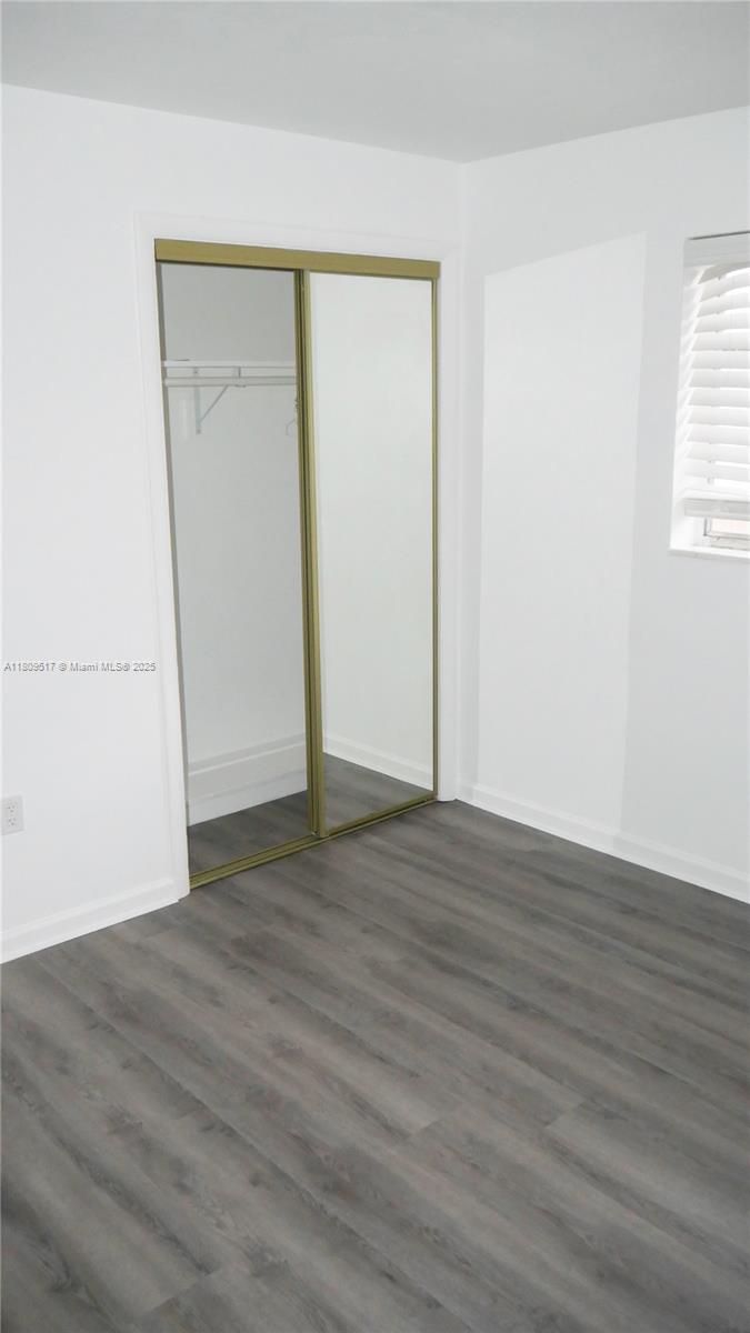 1930 Northwest 55th Street Miami, FL 33142 - Photo 17 of 30 an empty room with wooden floor and windows