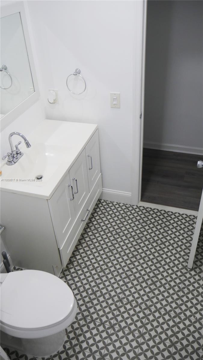 1930 Northwest 55th Street Miami, FL 33142 - Photo 19 of 30 a bathroom with a sink a toilet and a mirror