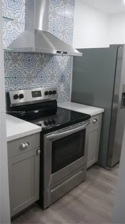 a stove top oven sitting inside of a kitchen