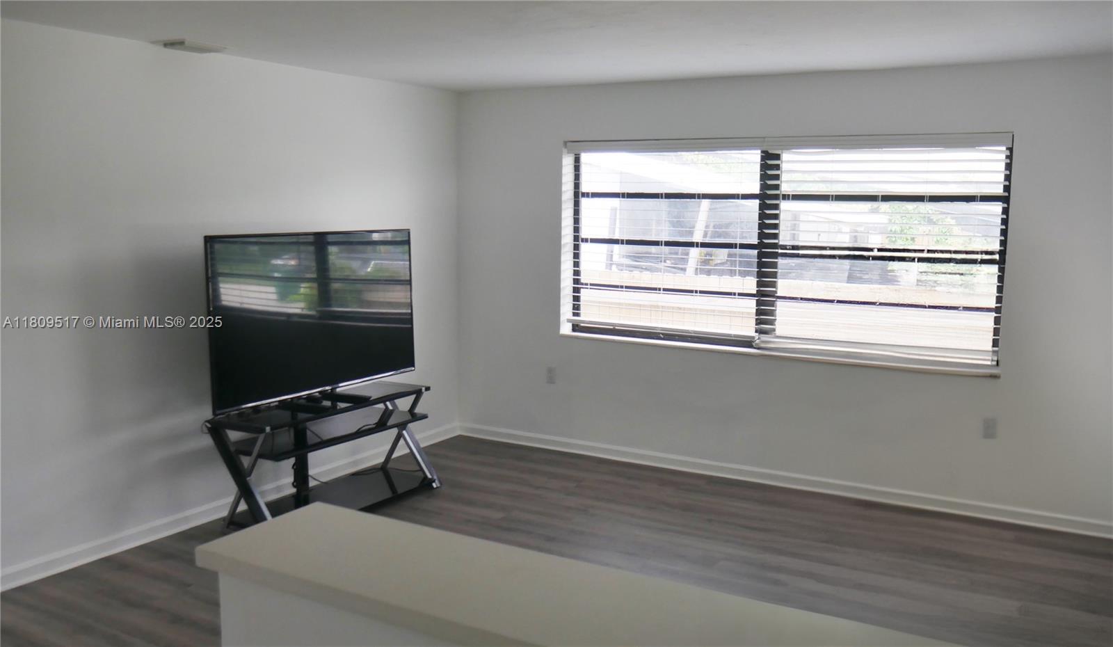 1930 Northwest 55th Street Miami, FL 33142 - Photo 4 of 30 a workspace with a window and wooden floor