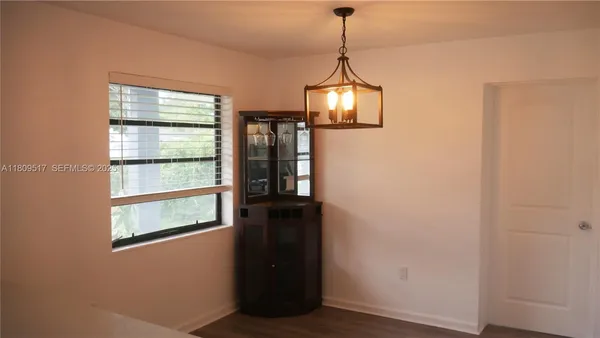a view of empty room with window and wooden floor