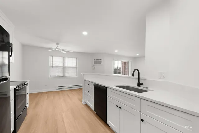 a kitchen with a sink stainless steel appliances and window