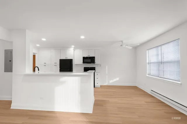 a view of kitchen with stainless steel appliances kitchen island sink and refrigerator