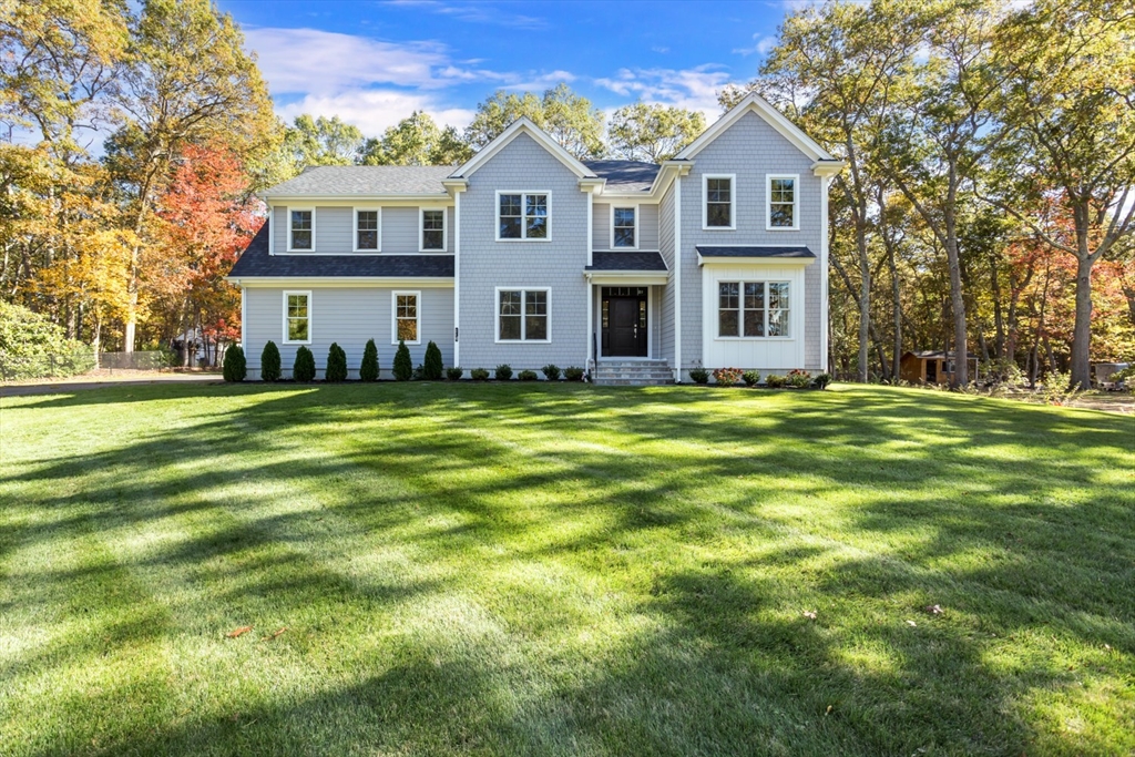 a view of a big house with a big yard and large trees